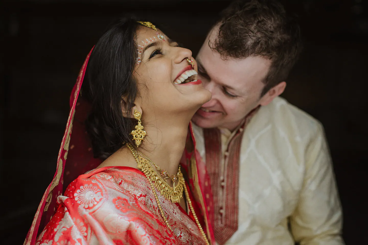 A couple laughing together during a multicultural wedding