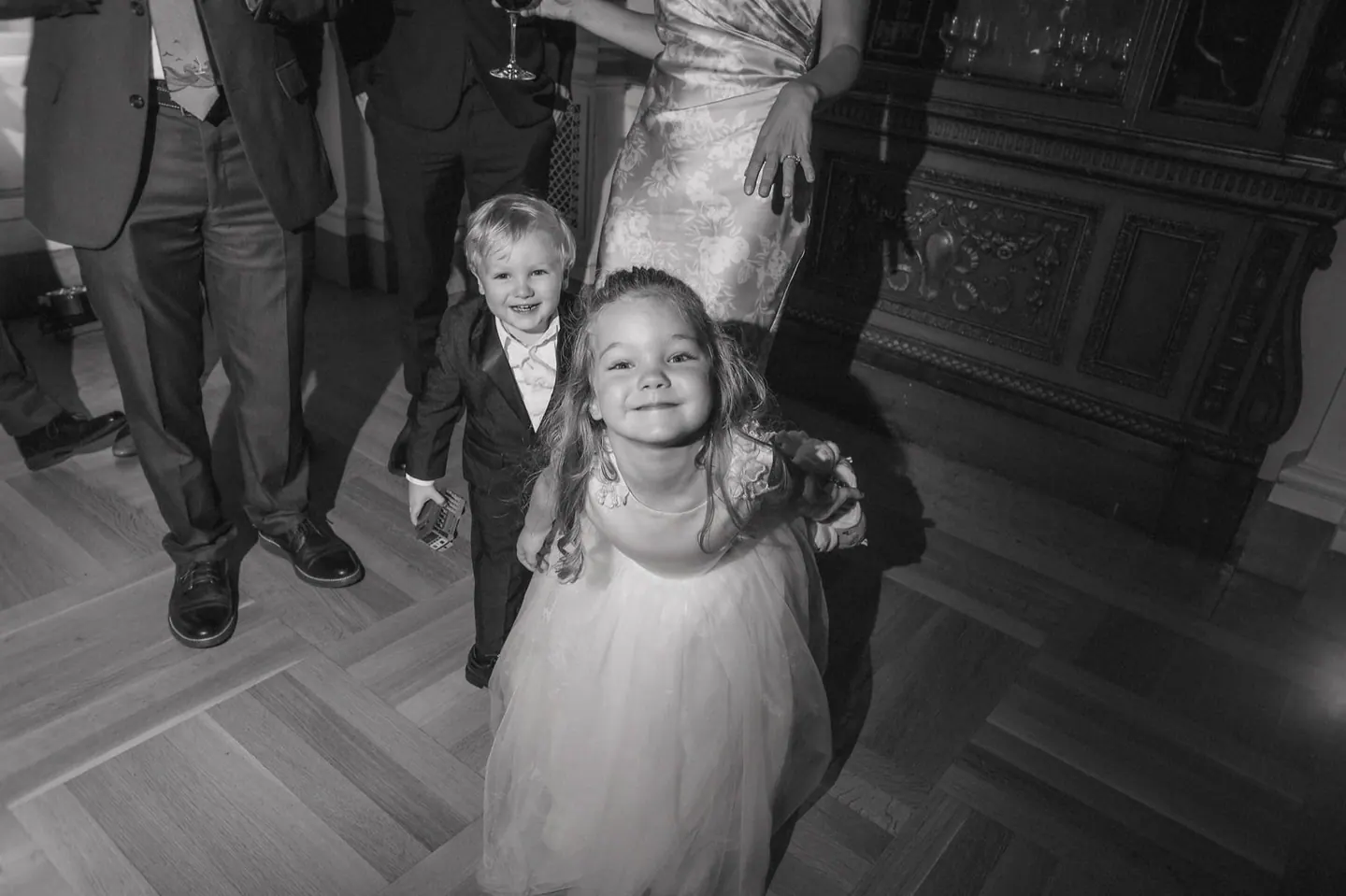 A flower girl pausing on a staircase in black and white