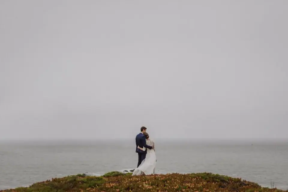 A couple standing together above a foggy Northern California coast