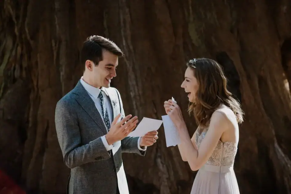 A couple reading private vows beneath the redwoods