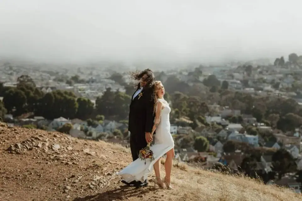 A newlywed couple overlooking a San Francisco neighborhood