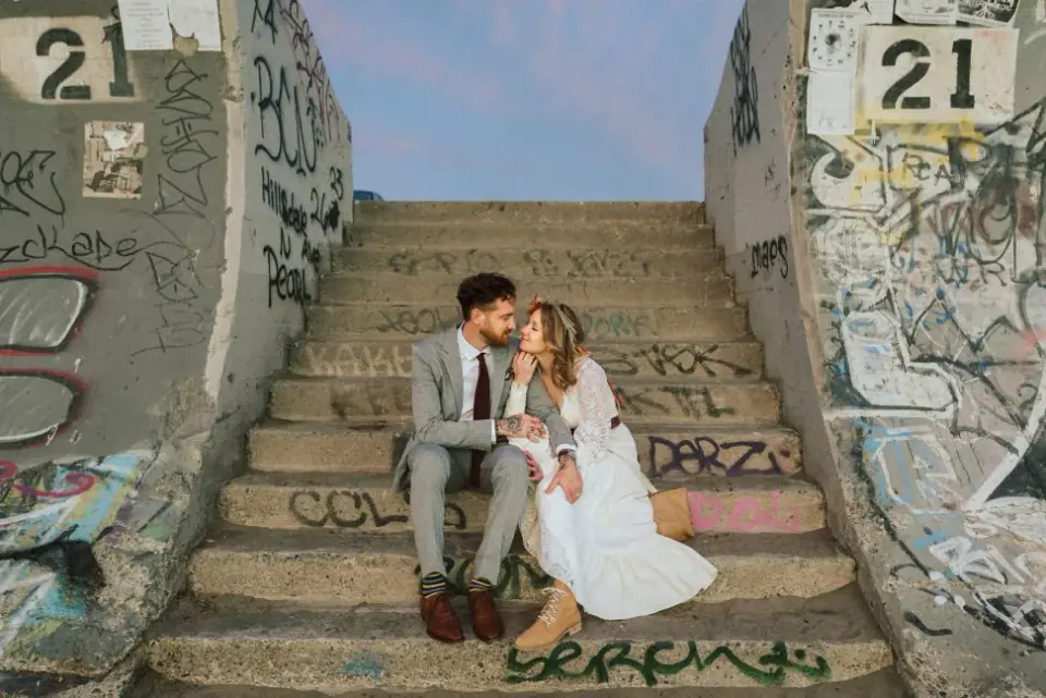 Newlyweds laughing together on colorful city steps