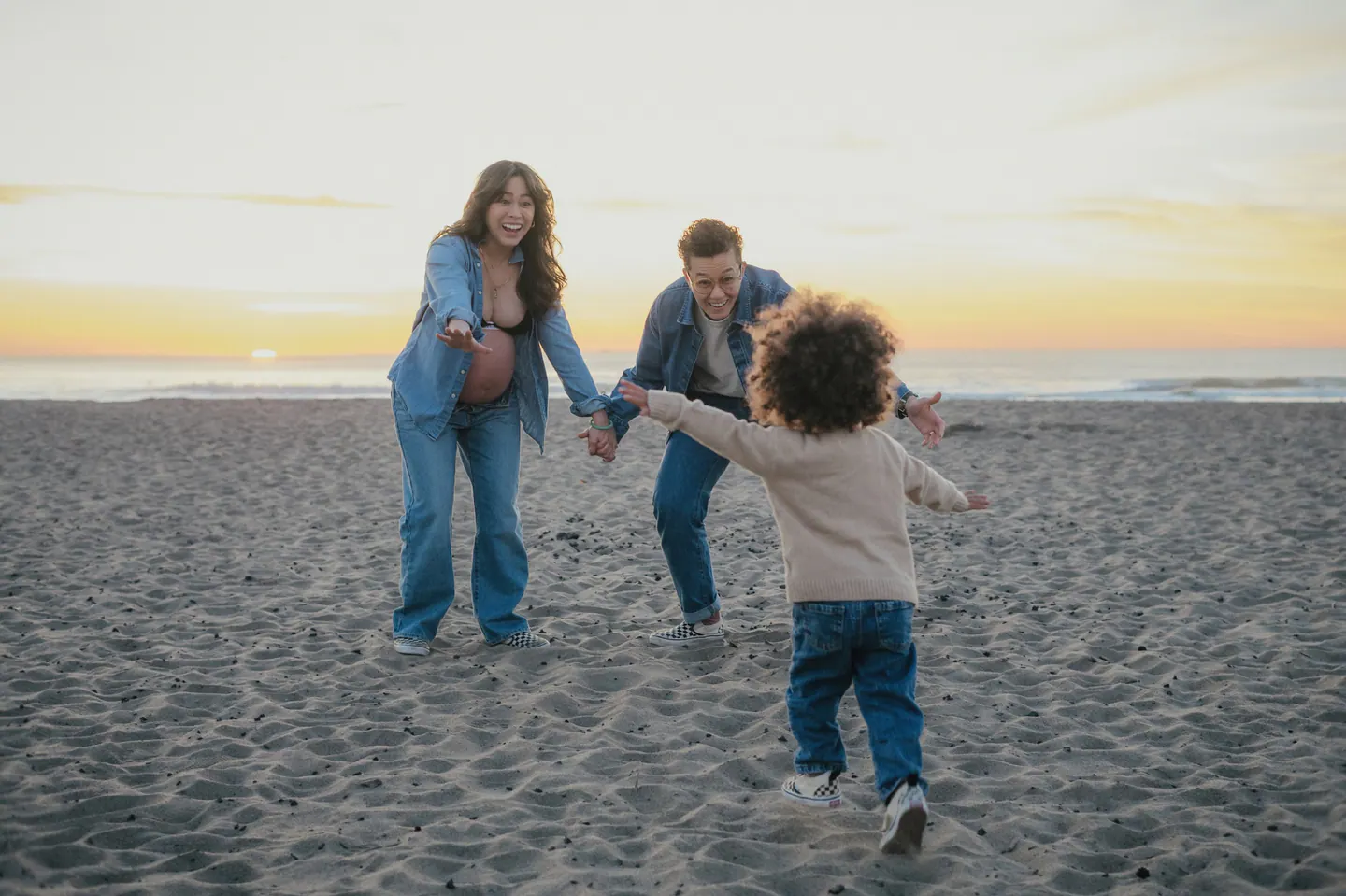 A child running toward their parents on the beach