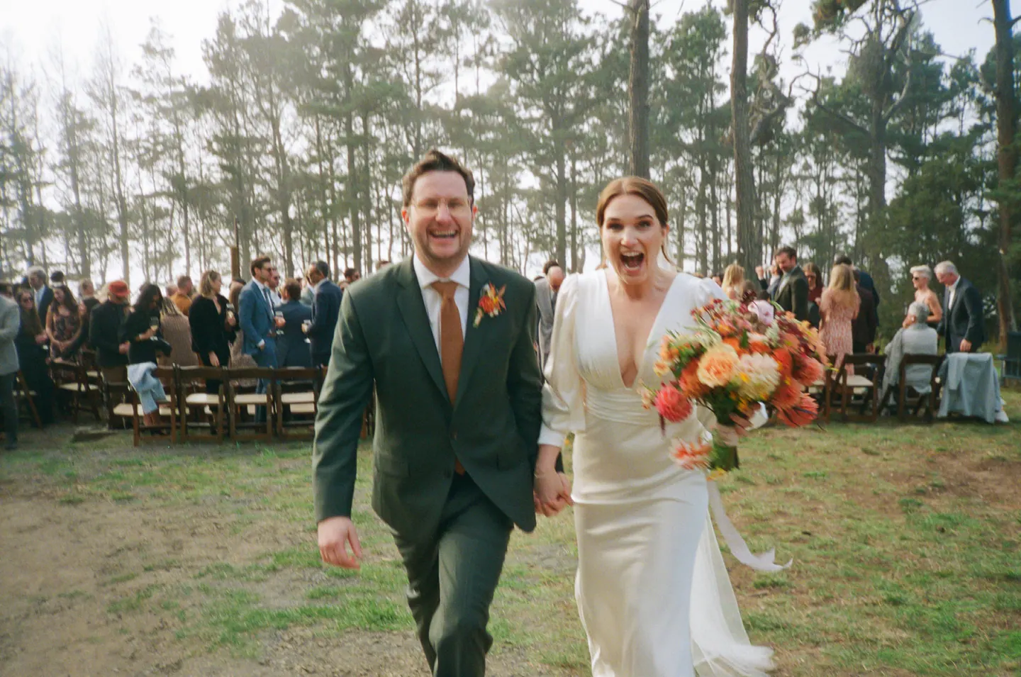 A newly married couple walking through their guests after a Marin ceremony