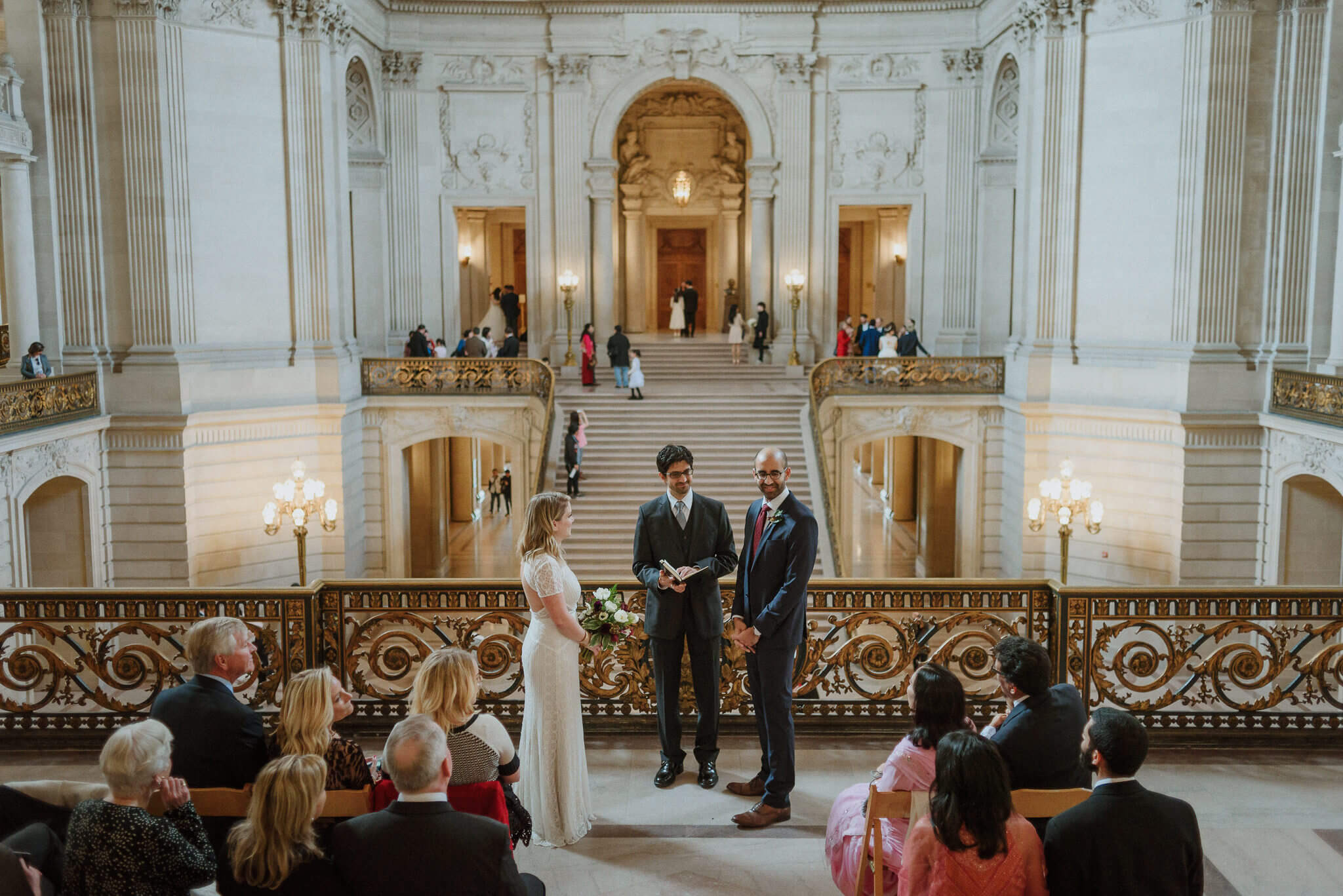 A wedding ceremony with guests at the Mayor's Balcony in San Francisco City Hall