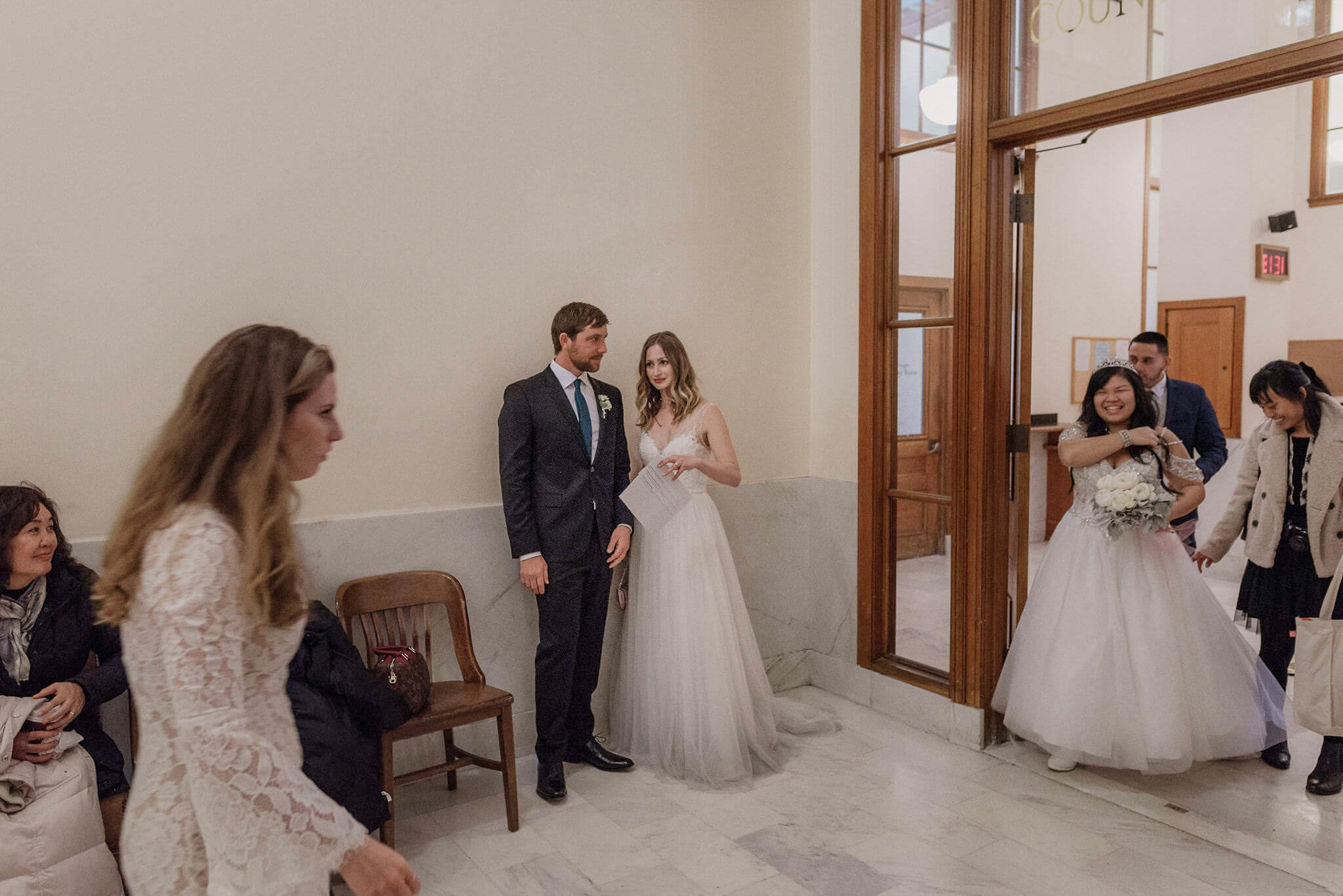 Several wedding groups crossing paths outside the County Clerk's office at San Francisco City Hall