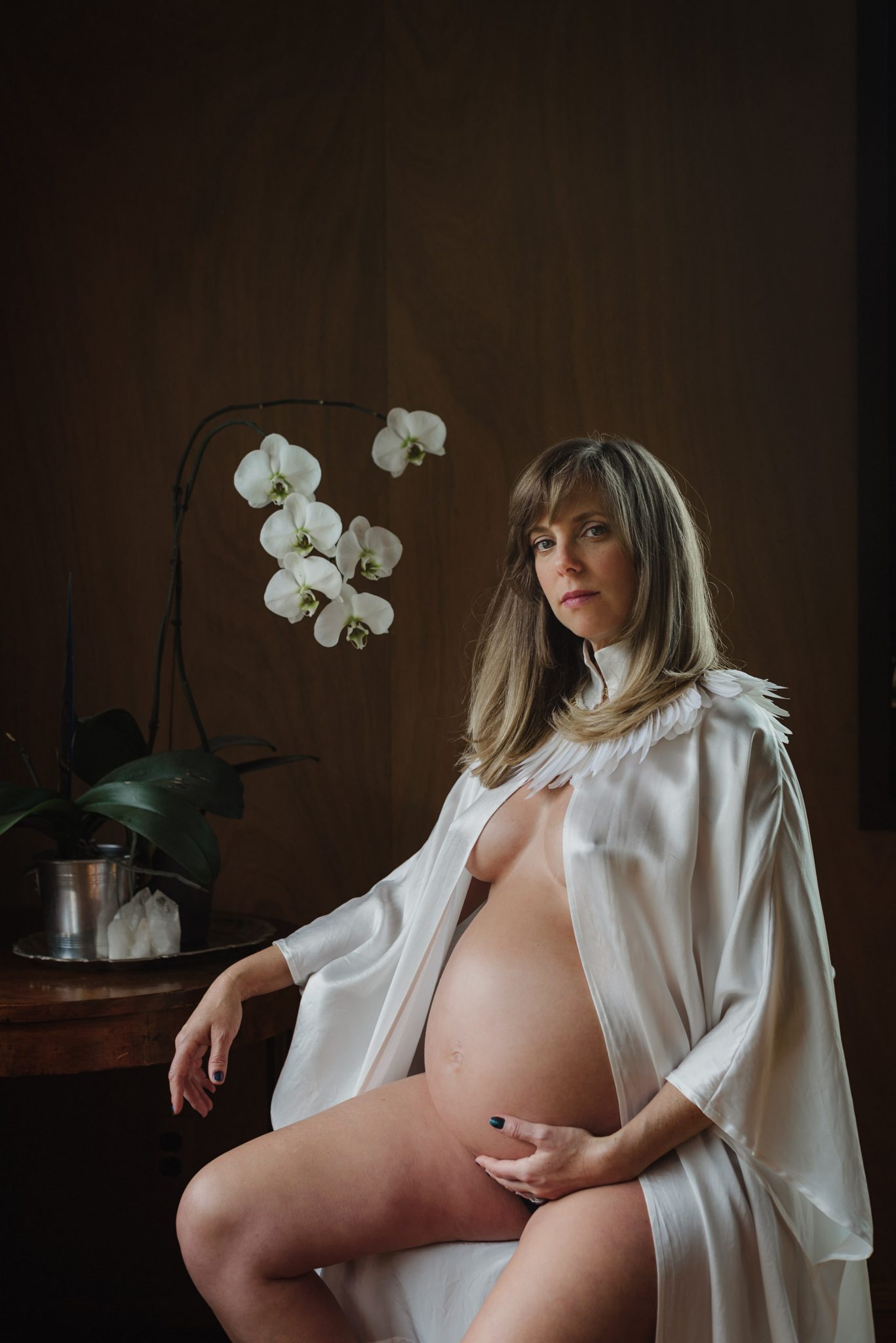 A quiet vertical maternity photograph at home