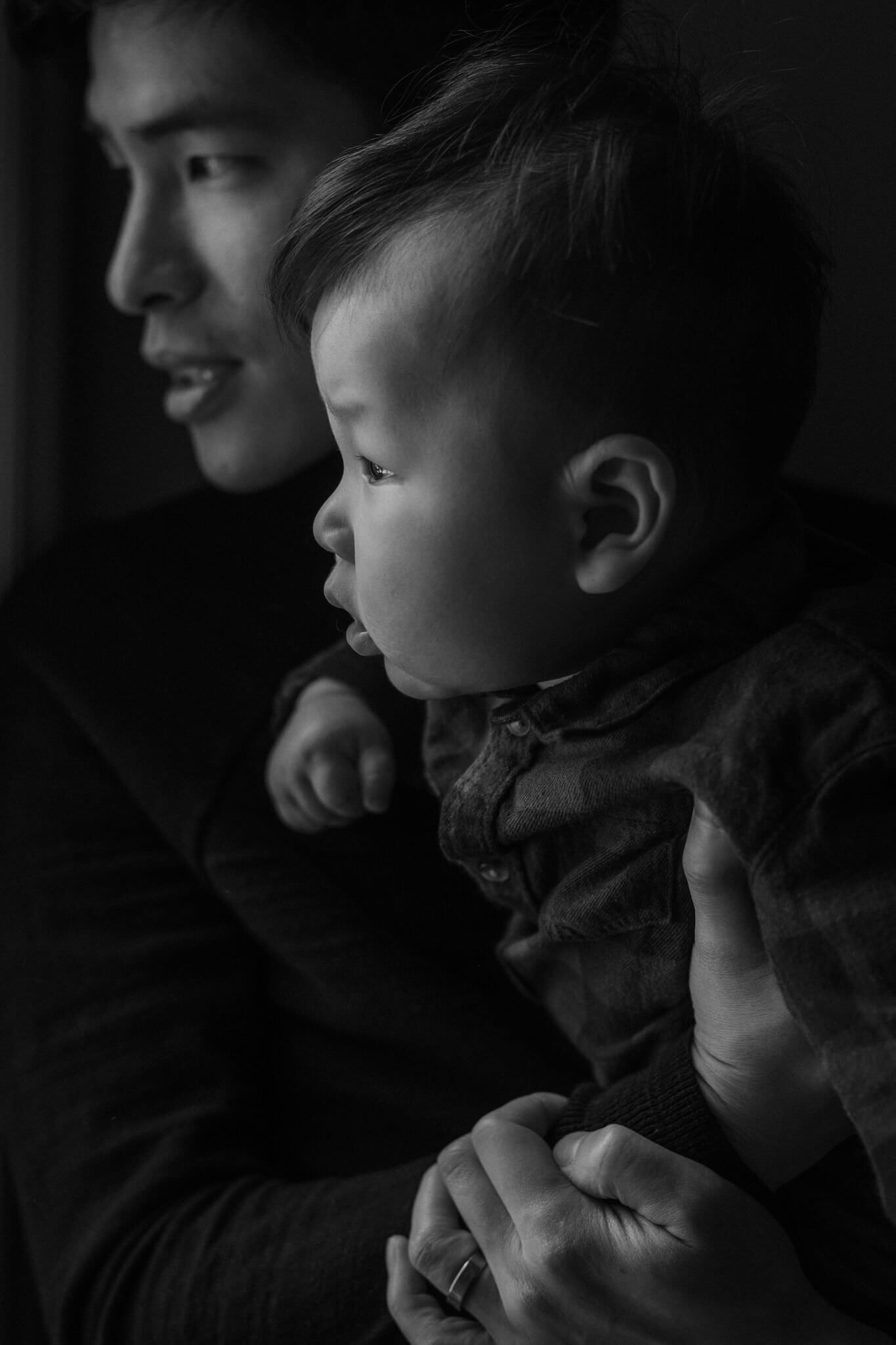 A black and white vertical family photograph at home