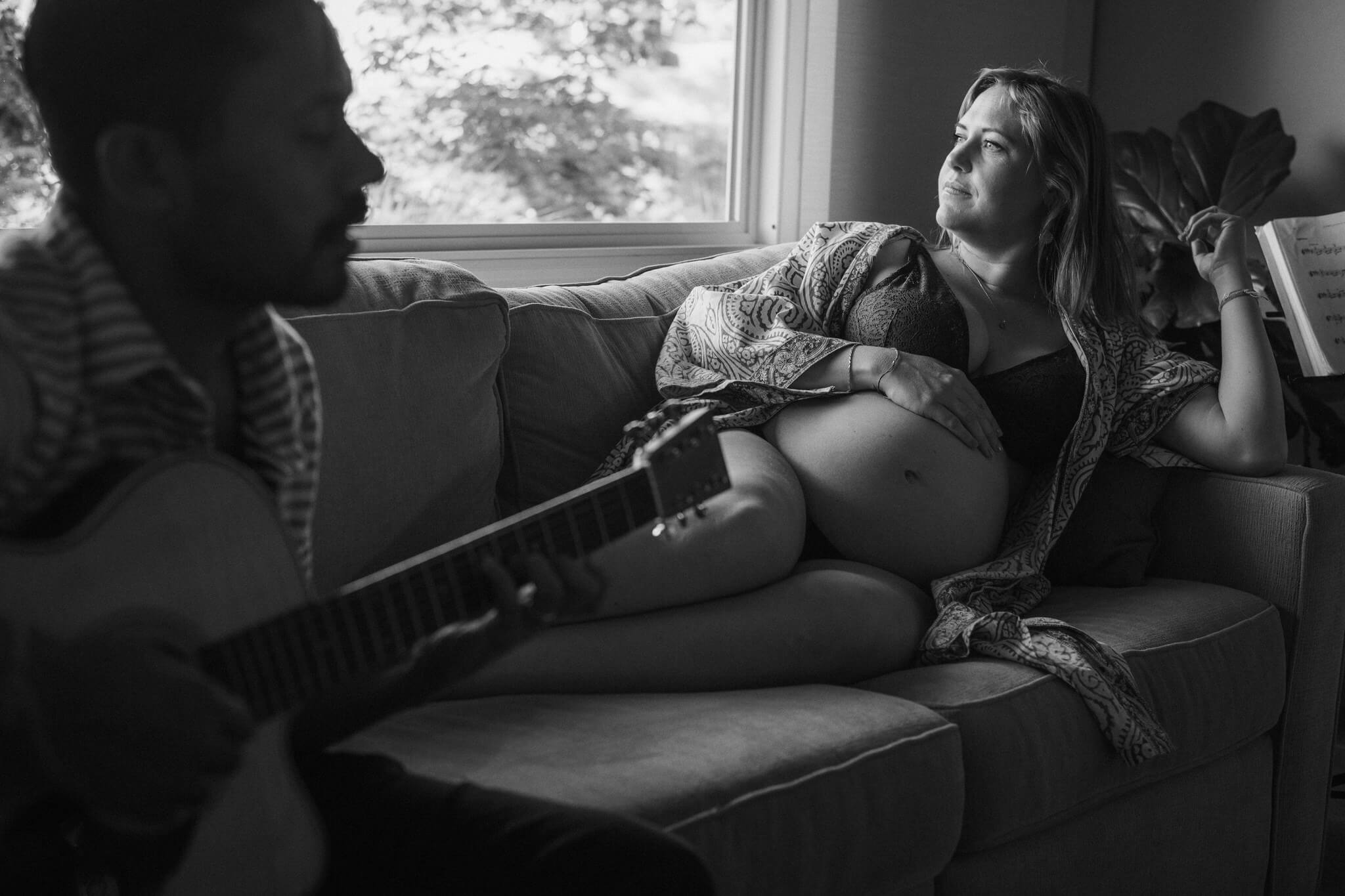 A candid black and white maternity photograph at home