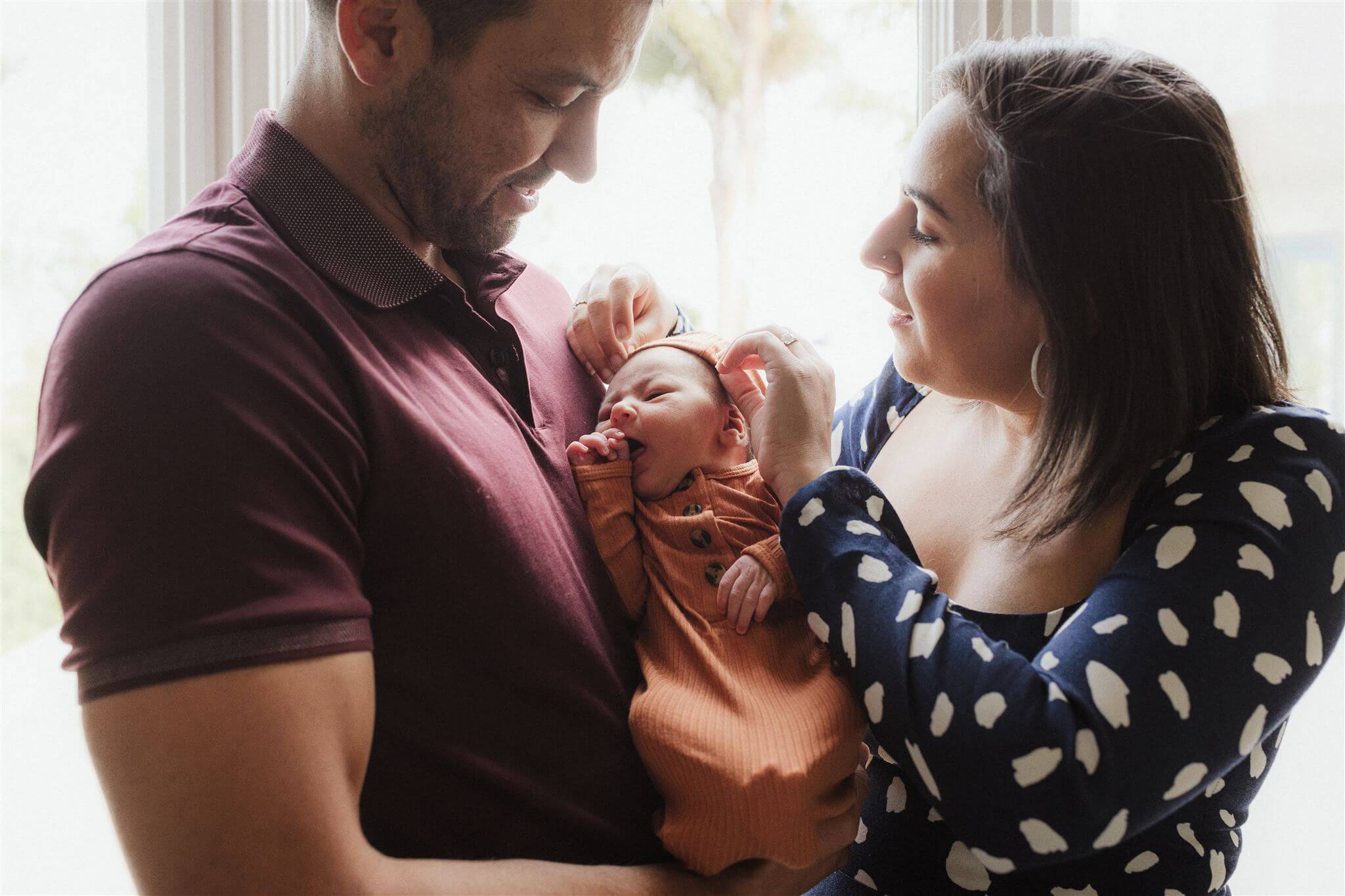 A newborn photographed naturally at home with family