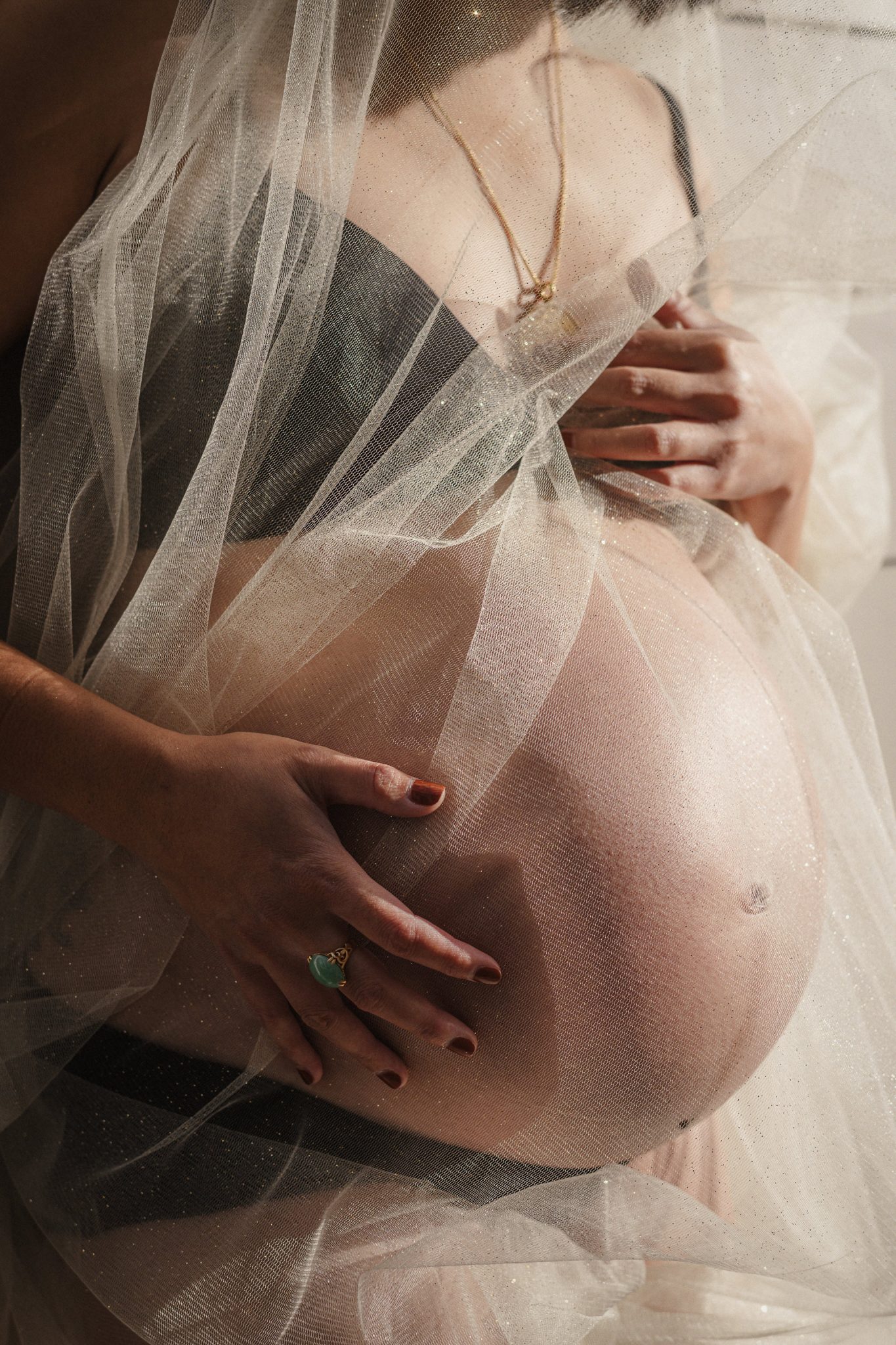 A vertical maternity portrait in soft natural light