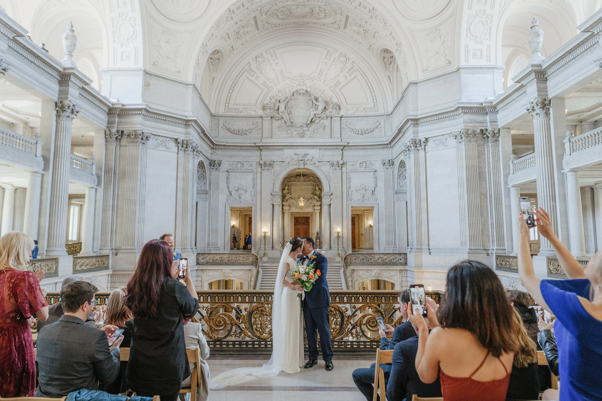 Guests photographing a couple during their San Francisco City Hall ceremony