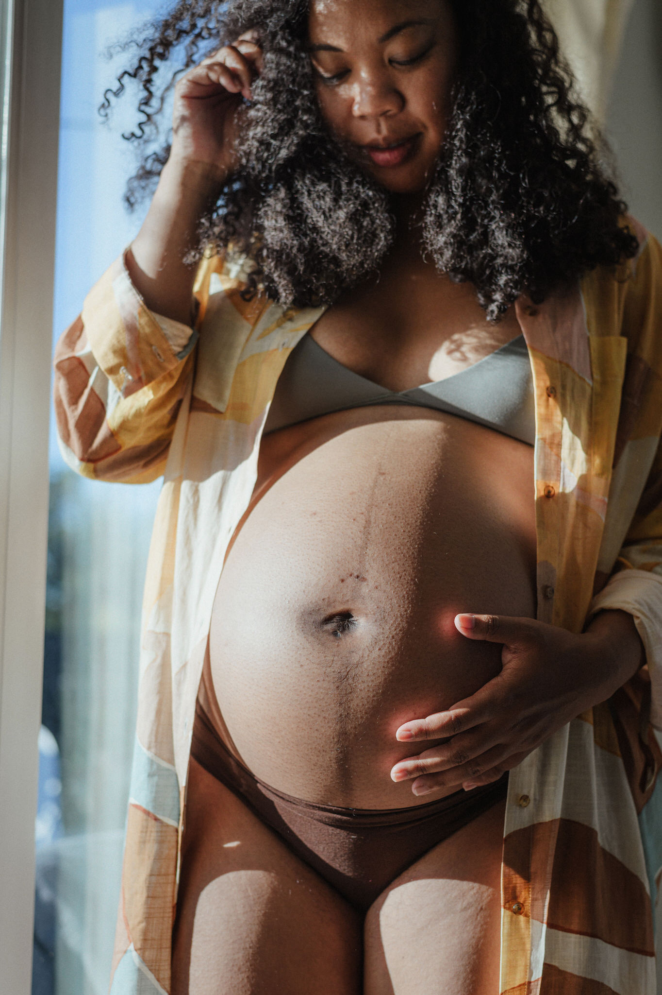 A vertical maternity portrait with a natural documentary feeling
