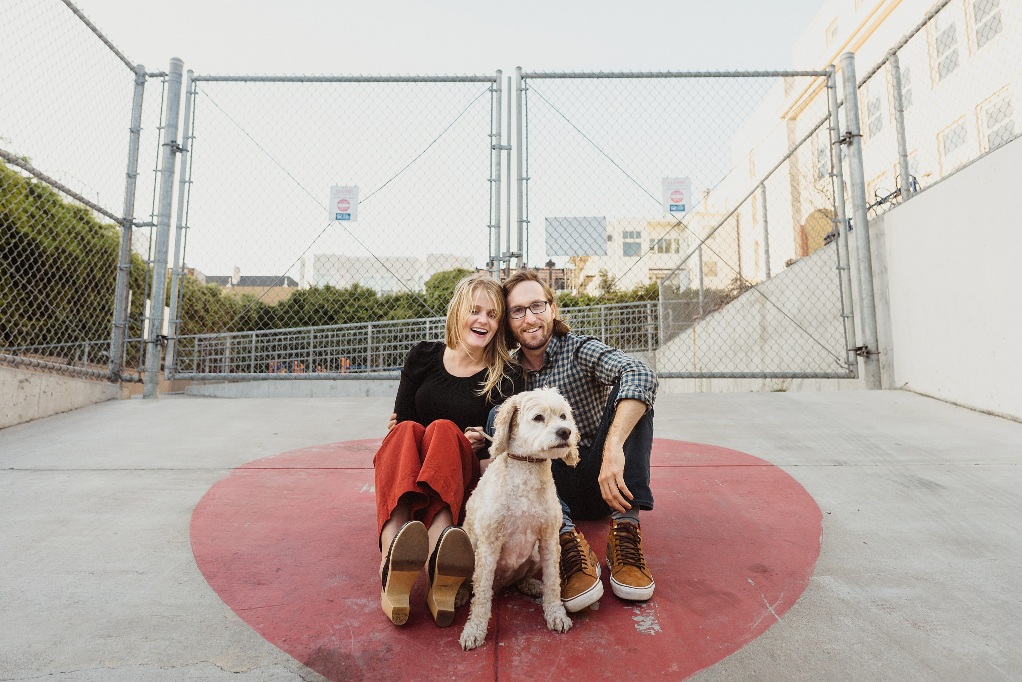 A playful engagement portrait with two dogs in San Francisco