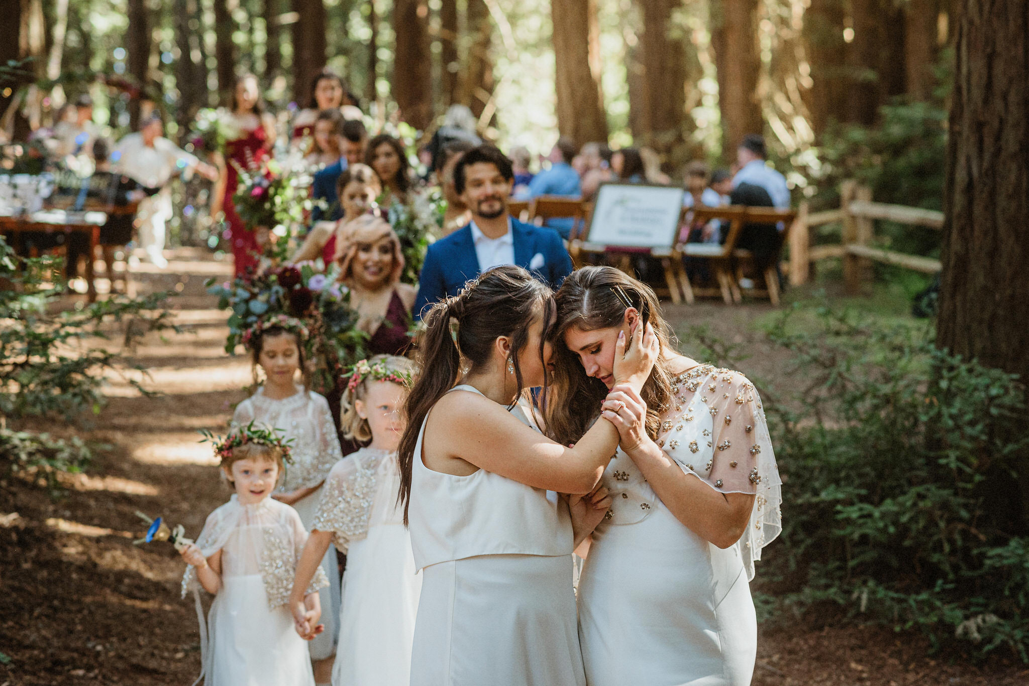 An emotional candid moment surrounded by wedding guests