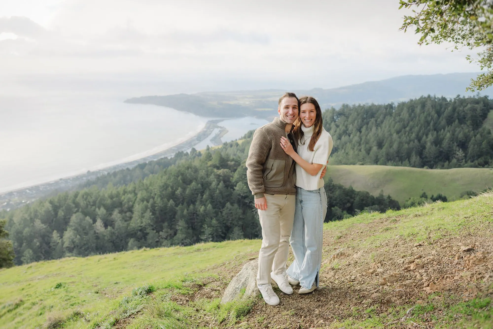 The newly engaged couple with the Marin coast below Mount Tam