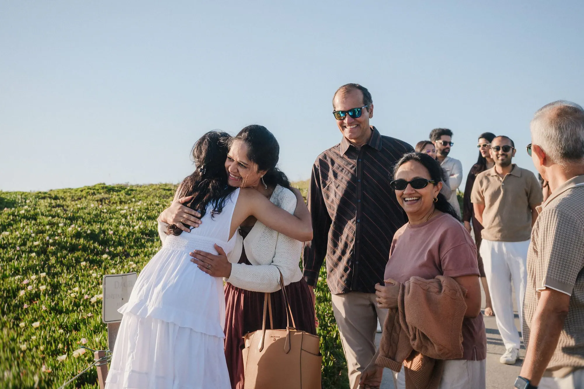 Family greeting the newly engaged couple above the Half Moon Bay coast